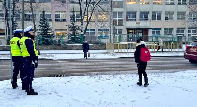 Zdjęcie przedstawia policjantów na przejściu dla pieszych przed Szkołą Podstawową nr 2 w Końskich