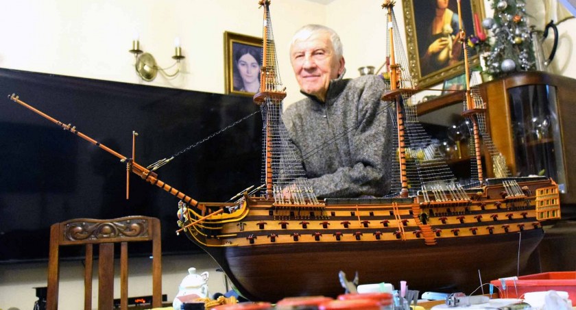 Zdjęcie konstruktora Waldemara Hajrycha w swojej stoczni na stole i modelu Victorii