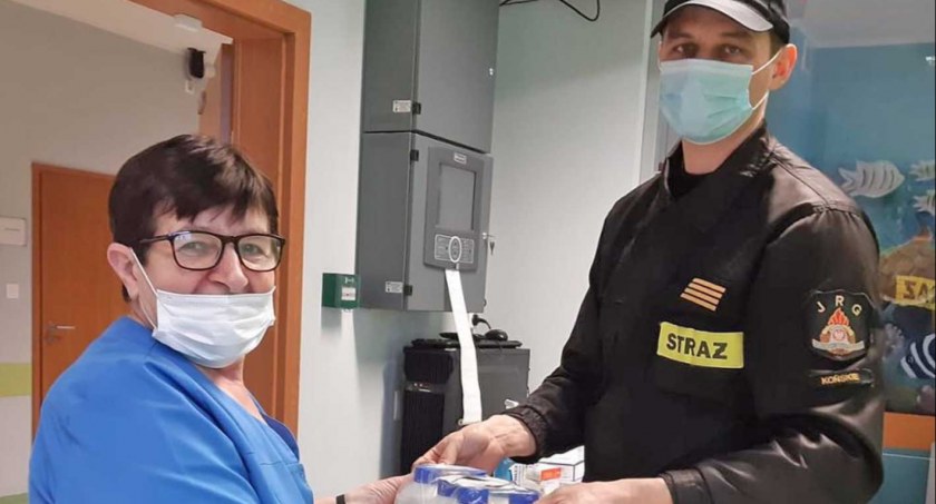 Zdjęcie, na którym strażak z JRG przekazuje płyny do dezynfekcji