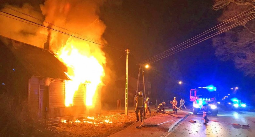 Zdjęcie domu objętego pożarem, który gaszą strażacy