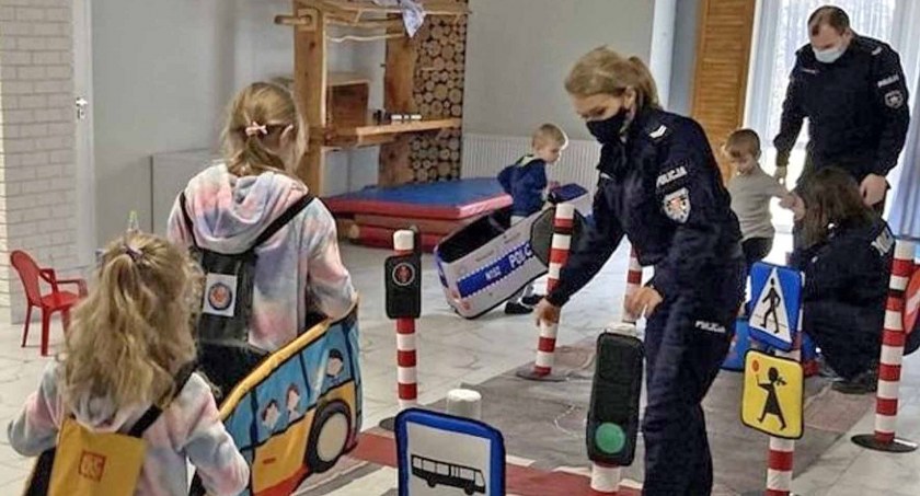Zdjęcie ukraińskich dzieci i koneckich policjantów w miniaturowym miasteczku ruchu drogowego
