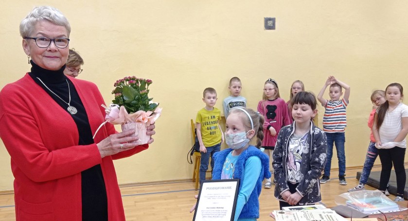 Zdjęcie poetki Janiny Malickiej, która otrzymała kwiaty i pisemne podziękowania za wizytę od dzieci ze szkoły w Radoszycach