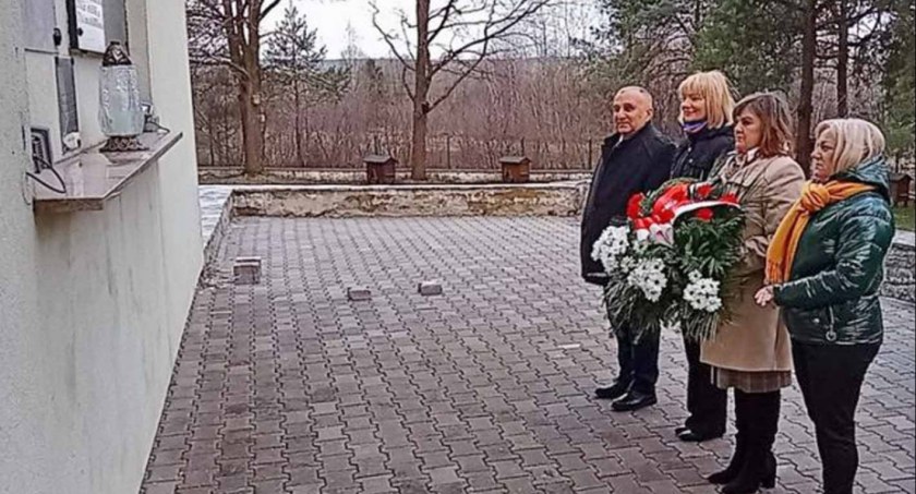 Zdjęcie delegacji wsi, gminy i starostwa przed czarną tablicą w Lutej