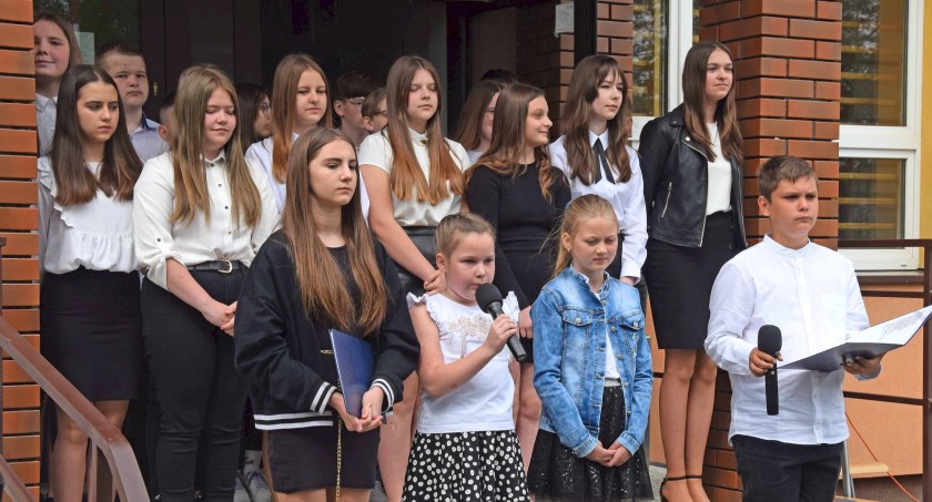 Zdjęcie występu uczniów, którzy zaprezentowali się na schodach przy wejściu do szkoły
