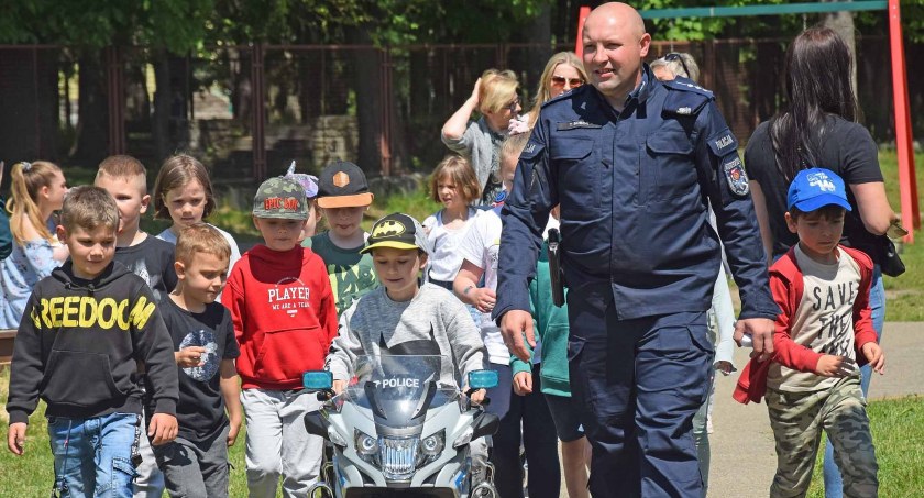 Zdjęcie dzieci i policjanta, którzy pilotują motocyklistę