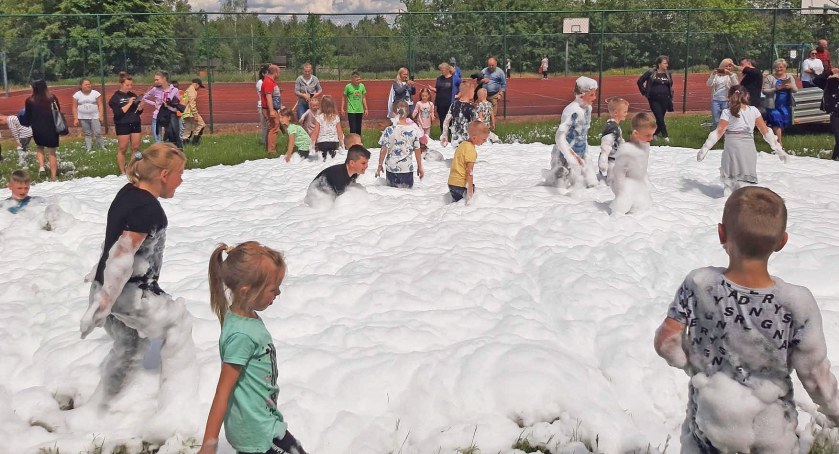 Zdjęcie dzieci bawiących się w pianie ciężkiej, którą sporządzili druhowie strażacy