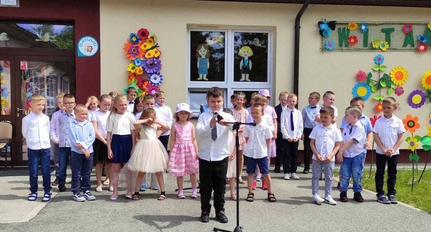 Zdjęcie przedszkolaków i uczniów, którzy prezentują program artystyczny przed nowym przedszkolem