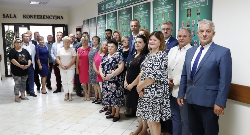 Pamiątkowe zdjęcie radnych, włodarzy powiatu i gminy przy tablicach upamiętniających jubileusz 30-lecia istnienia gminy