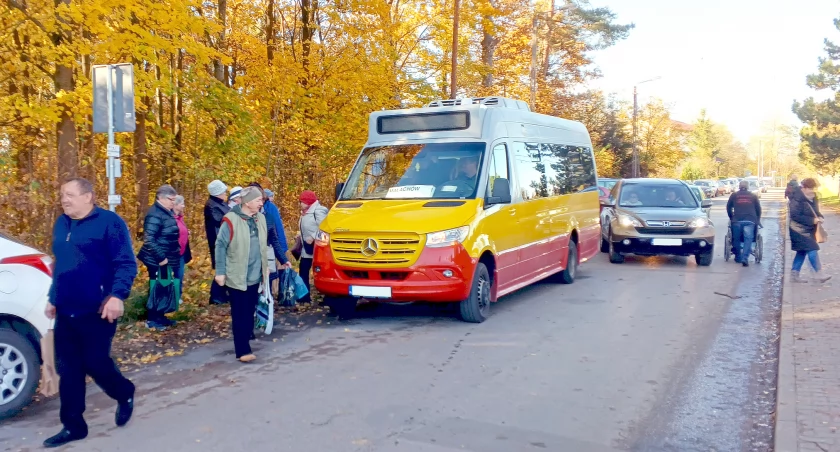 Zdjęcie pasażerów wysiadających z busa na koneckim cmentarzu