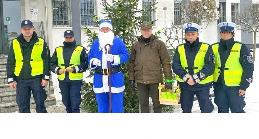 Zdjęcie Niebieskiego Mikołaja, policjantów i leśnika, którzy zakończyli zdobienie choinki