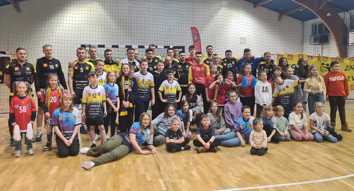 Pamiątkowe zdjęcie szczypiornistów KSSPR Końskie z najmłodszymi kibicami po meczu z Górnikiem Zabrze
