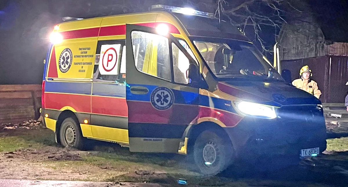 Zdjęcie karetki z pacjentem wyciąganej z błota przez strażaków