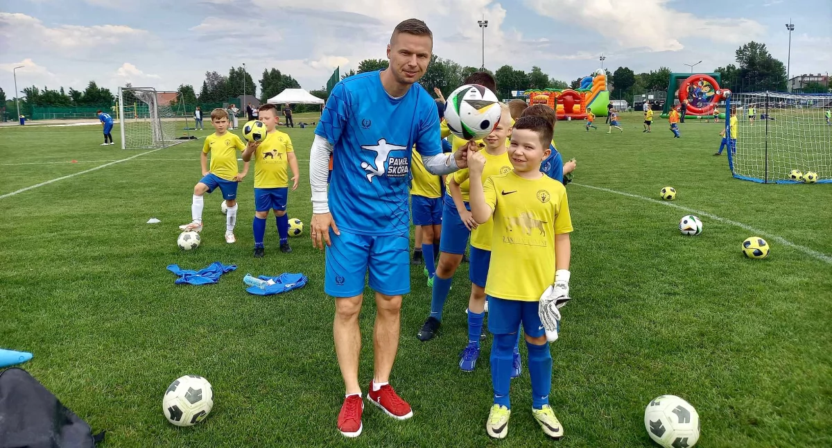 Zdjęcie mistrza świata freestyle football Pawła Skóry i dzieci podczas koneckiego Turnieju Gier i Dnia Dziecka
