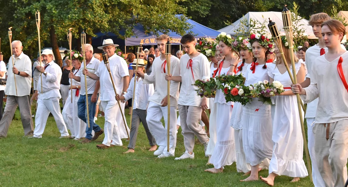 Zdjęcie uczestników inscenizacji zmierzających do wody z wiankami i pannami