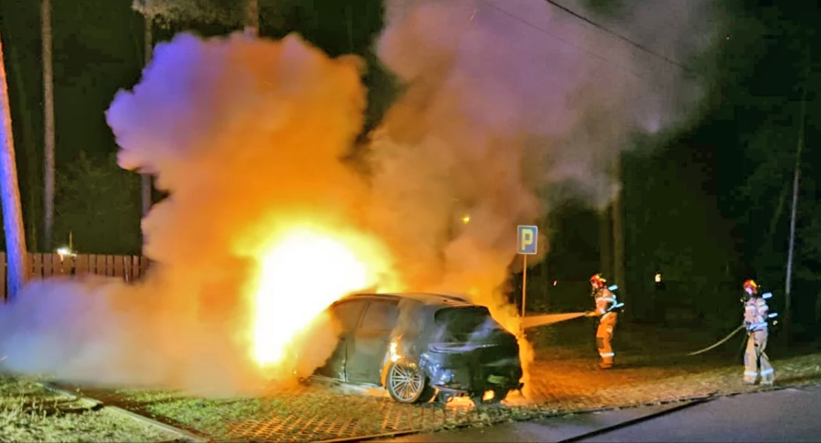 Zdjęcie strażaków gaszcych pożar, który wybuchł w przedniej części pojazdu
