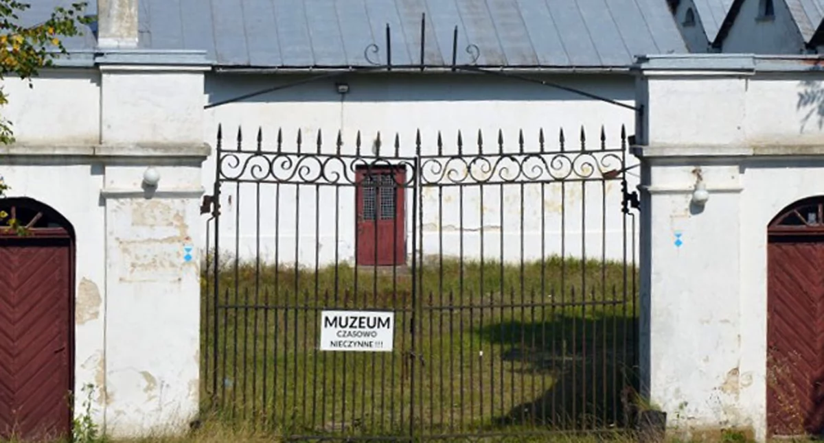 Zdjęcie bramy wejście głównego, na której wisi ogłoszenie: Muzeum czasowo nieczynne