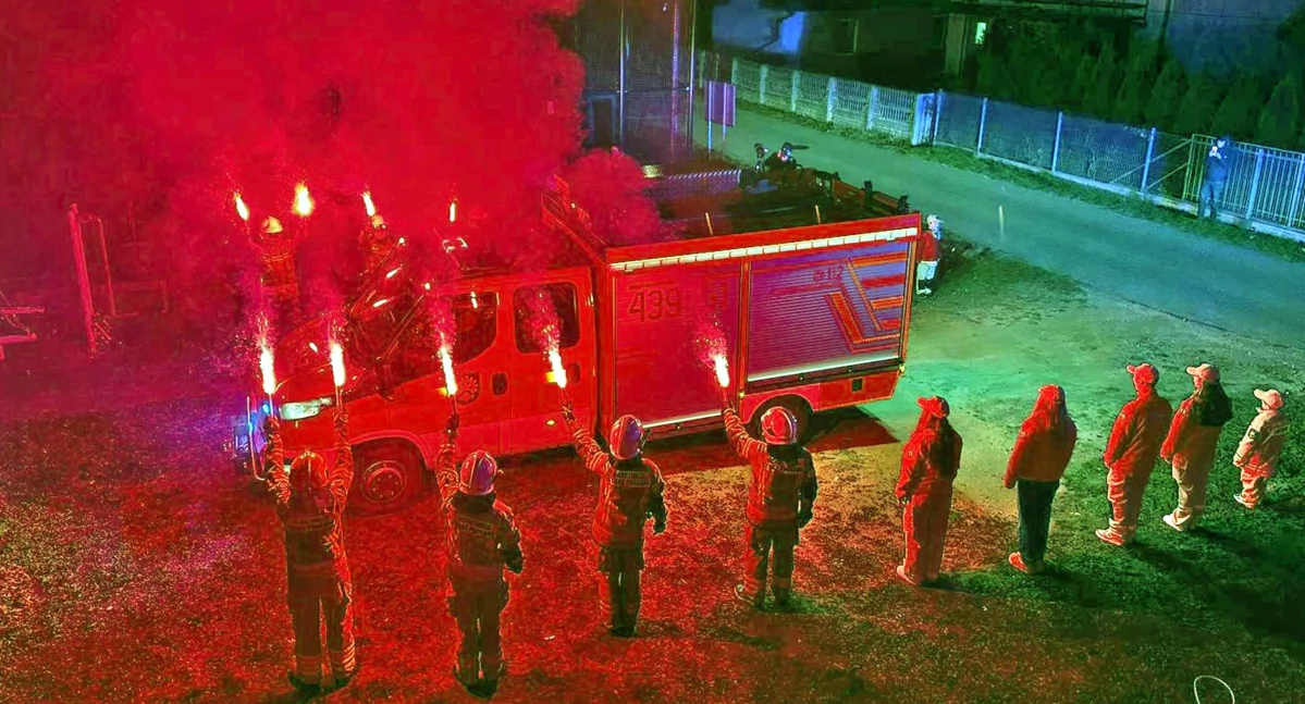 Zdjęcie z powitania płonącymi pochodniami nowego samochodu strażackiego w Rudzie Malenieckiej