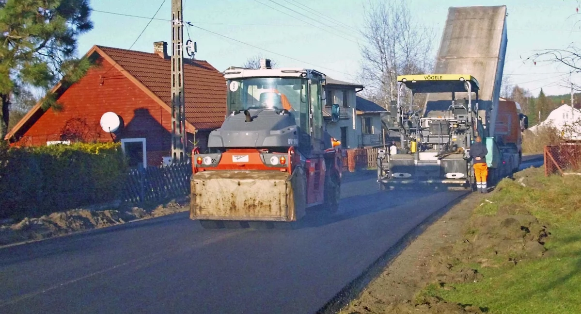 Zdjęcie drogowców, którzy przy pomocy maszyn układają dywanik asfaltowy na odcinku od krzyżówek w kierunku Odrowąża