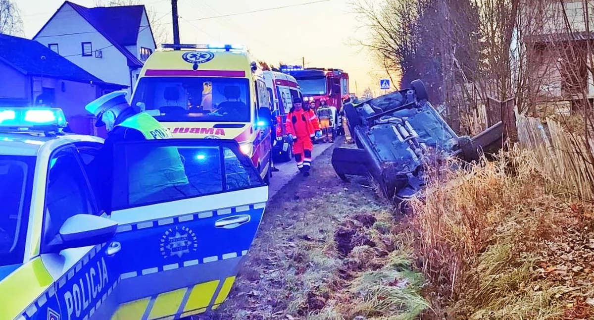 Zdjęcie skody w rowie kołami do góry. Służby pracują