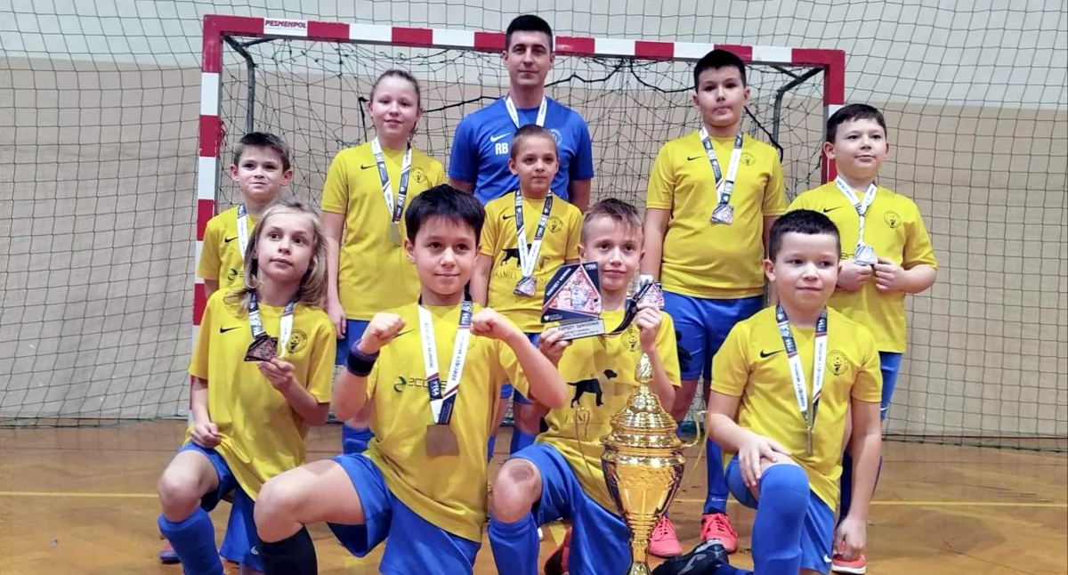 Zdjęcie zwycięskiej drużyny Akademii Piłkarskiej Champions Końskie z trenerem Rafałem Bednarzem