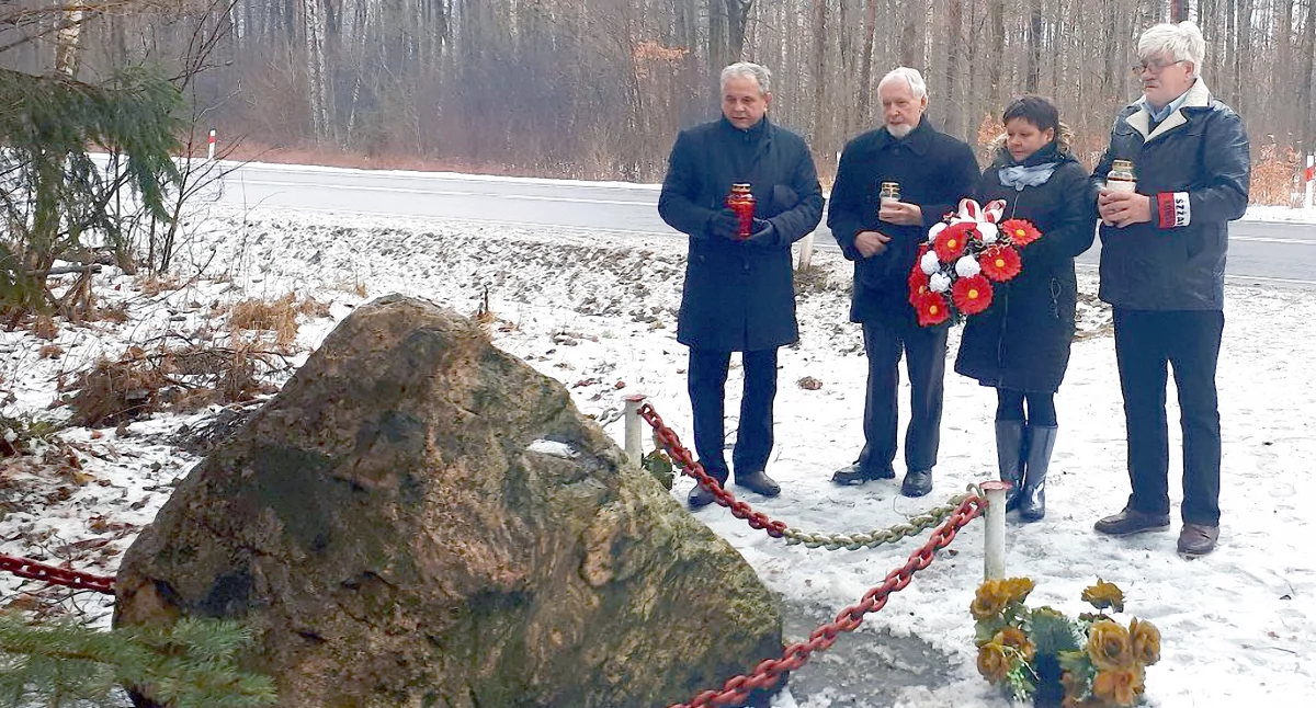 Zdjęcie delegacji ze światłami pamięci i składającej kwiaty przy pamiątkowym kamieniu w lesie koło Piły (zdjęcie archiwalne)