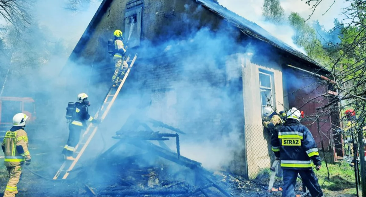 Zdjęcie strażaków, którzy gaszą pożar pustego domu w Kornicy