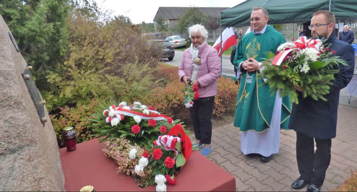 Zdjęcie - kwiaty pod pomnikiem Tereski składa ks. Marek Relidzyński i osoby towarzyszące