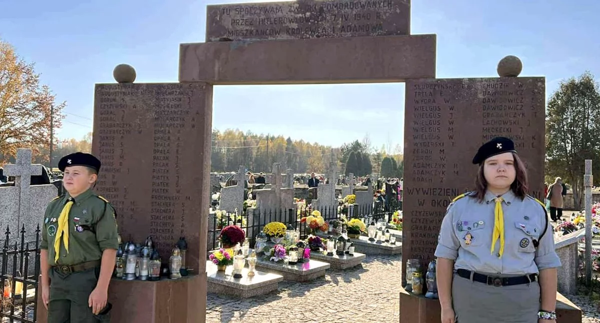 Zdjęcie harcerzy, którzy pełnią wartę honorową przy bramie wejściowej na cmentarz mieszkańców gminy zamordowanych 7 kwietnia 1940 r.