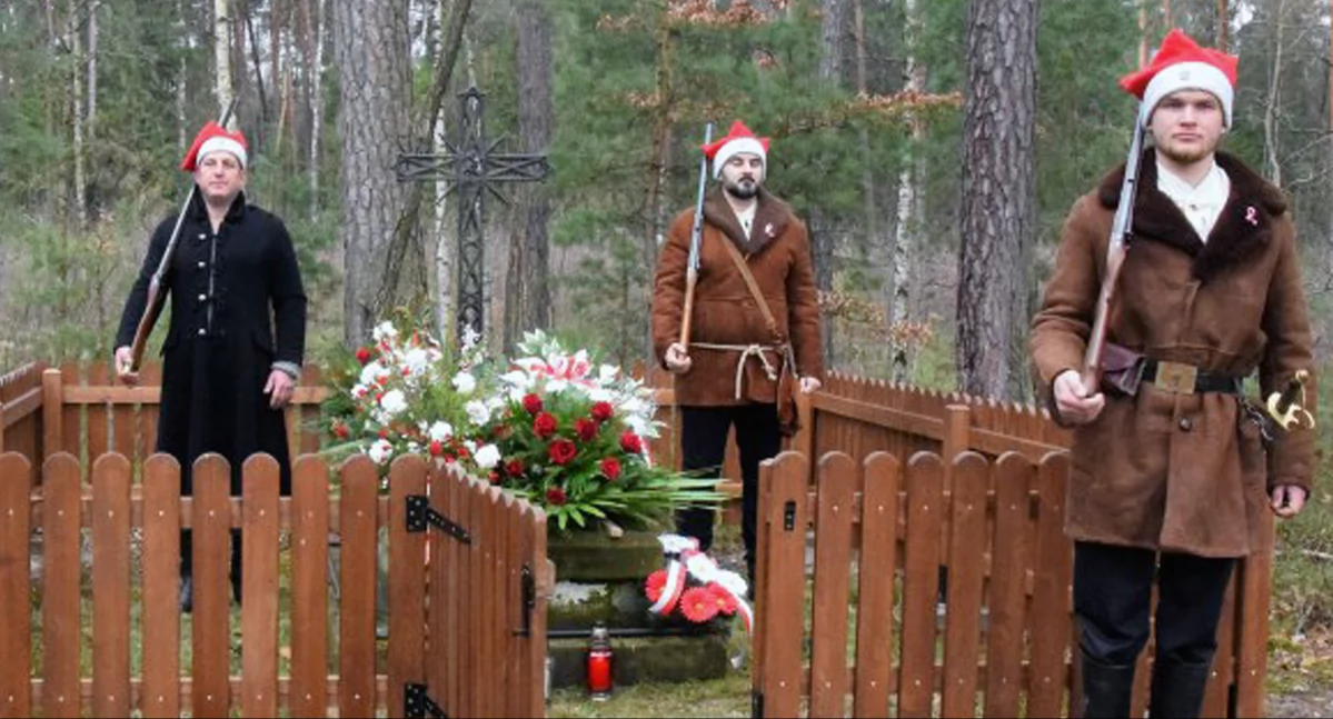 Zdjęcie osób w powstańczych strojach pełniących wartę przy mogile powstańców w Uroczysku Ormanicha