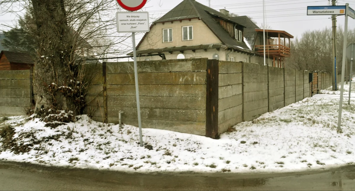 Zdjęcie - za płotem, w tych budynkach mieszkali funkcyjni Niemcy, a dalej rozciągał się teren obozu