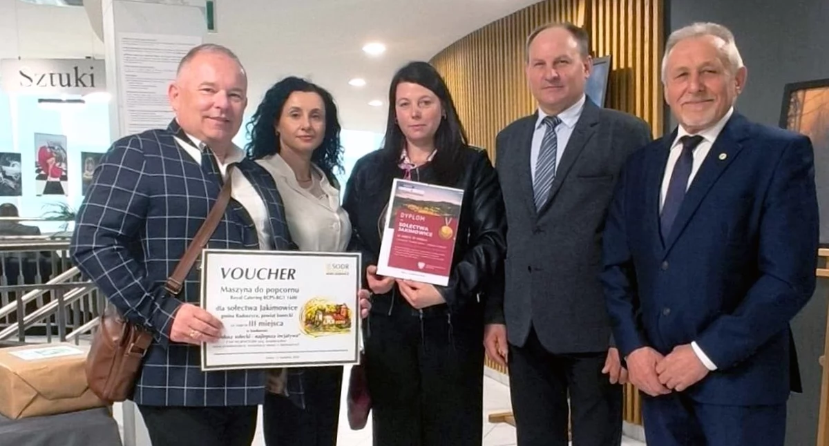 Zdjęcie przedstawicieli gminy i sołectwa, którzy odbierają nagrodę